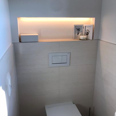 Toilette gefliest mit indirekter Beleuchtung